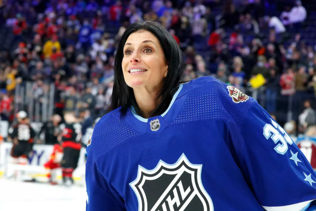 Photograph of women's rights and hockey legend Manon Rhéaume participating in the 2022 NHL All-Star game she's wearing a Tampa Bay Lightning blue colored NHL All-Star jersey with the number 33, the same she wore in her time with the Lghtning.